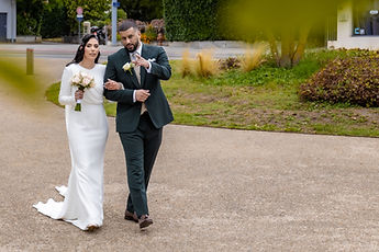 The couple walking, behind a bed of flowers