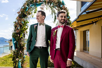 Portrait of the grooms beneath the arch, smiling