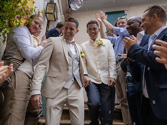 Fabien and Jayson, smiling newlyweds under a cloud of soap bubbles