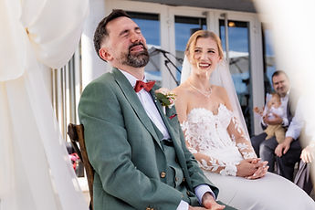 The groom bursts out laughing during the ceremony