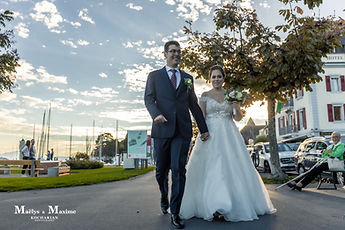 The newlyweds hand in hand on the quay