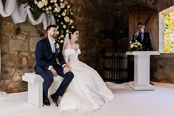 The couple seated side by side during the secular ceremony