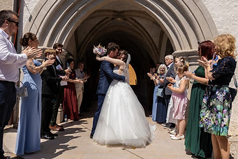 Beneath the porch, Lucie and Patrick embrace among their loved ones