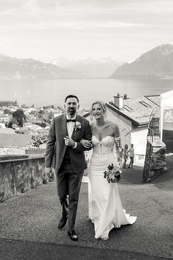 The couple walking together, the lake behind them, in black and white