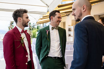 The grooms chat with a guest