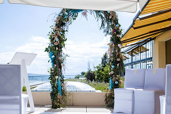 The flower arch and the white chairs before the ceremony