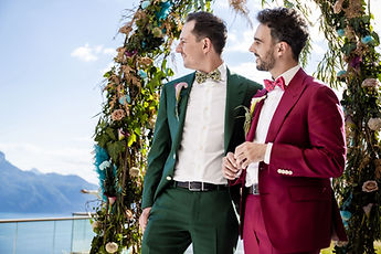 The grooms beneath the arch, hand in hand