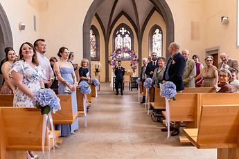 The guests standing, turned towards the church entrance