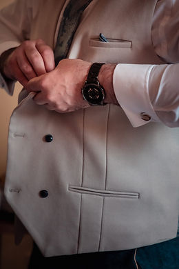 Groom preparing his waistcoat before the wedding