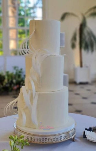 White fondant wedding cake decorated with white wafer paper