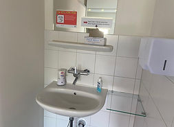 Waschbecken mit Anweisungen und Hygienemasken