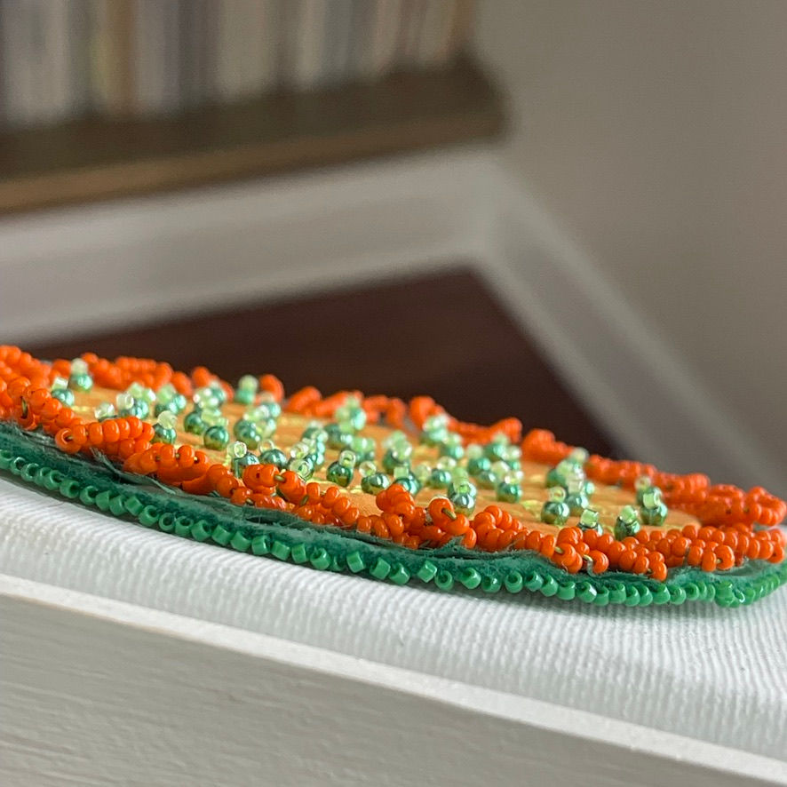 Beaded orange and green mixed media artwork