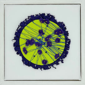 Circular lime green fiber art with purple boarder and fluffy purple flowered center on a white canvas in a white frame.