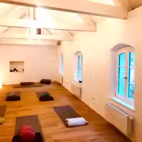 Yogaraum mit Yogamatten und atmosphärischem Licht