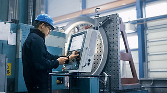 Factory worker is programming a CNC mill