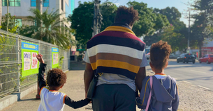 Vitor Del Rey e seus dois filhos caminhando pela calçada