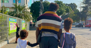 Vitor Del Rey e seus dois filhos caminhando pela calçada