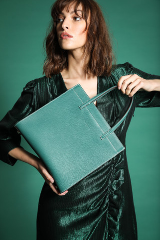 Femme dans une robe verte tenant un sac vert Just Campagne
