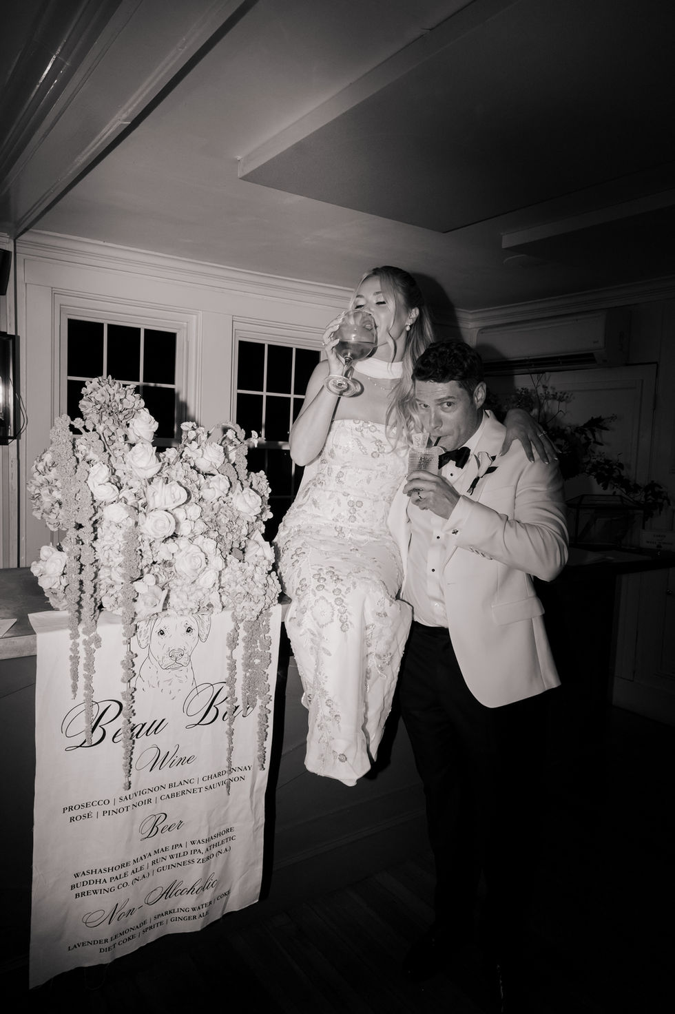 Bride and groom celebrating with drinks, elegant setting.