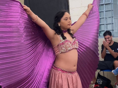 Luana dançando com asas lilás e sendo aplaudida.