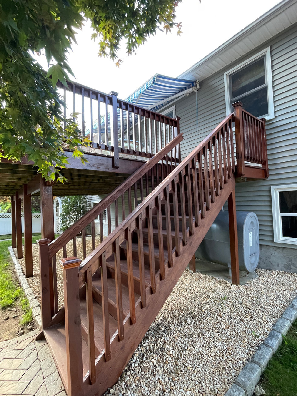 Restored exterior deck stairs after extensive carpentry repairs, wood replacement, preparation, and application of two coats of semi-transparent stain.