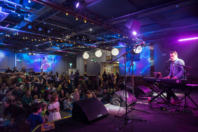 A full room at the Brudenell Social Club, watching an artist perform at a Made With Music Mini-Gig.