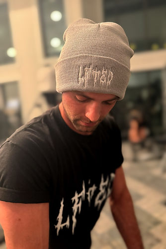 man in a gym wearing a lfted fitness grey beanie doing tricep extensions