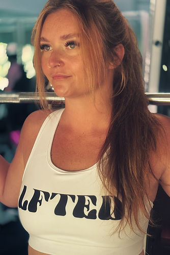 woman doing a barbell squat in a gym wearing a lfted fitness sports bra