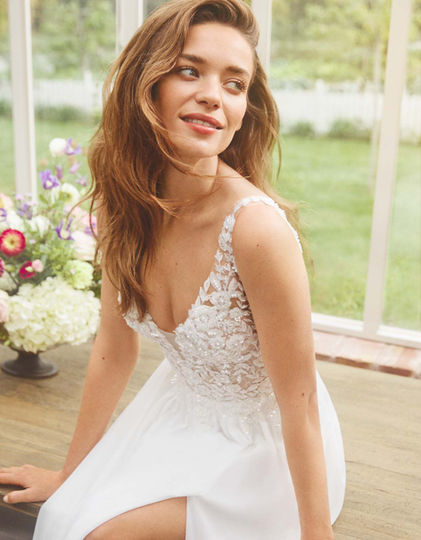 Robe de mariée Filipa signée Alberto Palatchi, coupe A-line gracieuse en mousseline, avec corsage en dentelle perlée définissant la taille, un dos en V et jupe plissée délicatement, en vente chez Noces de Cristal à Nancy.