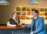 Picture of co-owners Jay and Lisa Anderson laughing at the wine bar in Walla Walla tasting room