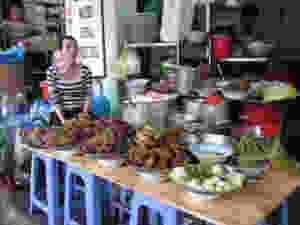 Woman selling cooked food at a market in Vietnam