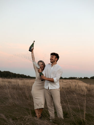 paarfoto - abenstimmung mit sekt und einem pärchen das sich freut