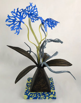 Painted fabric sculptured representing plant with lacy blue flowers and bronze coloured leaves. On 6" base painted yellow and blue.