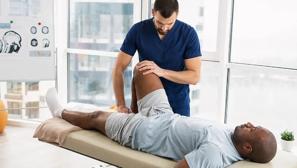 Chiropractor assessing an adult patient’s hip and leg mobility during a chiropractic appointment.