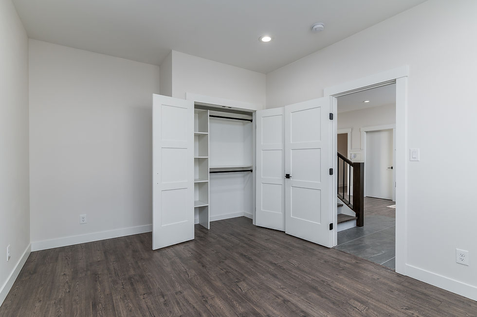 A bedroom with an empty open closet, with closet shelving.