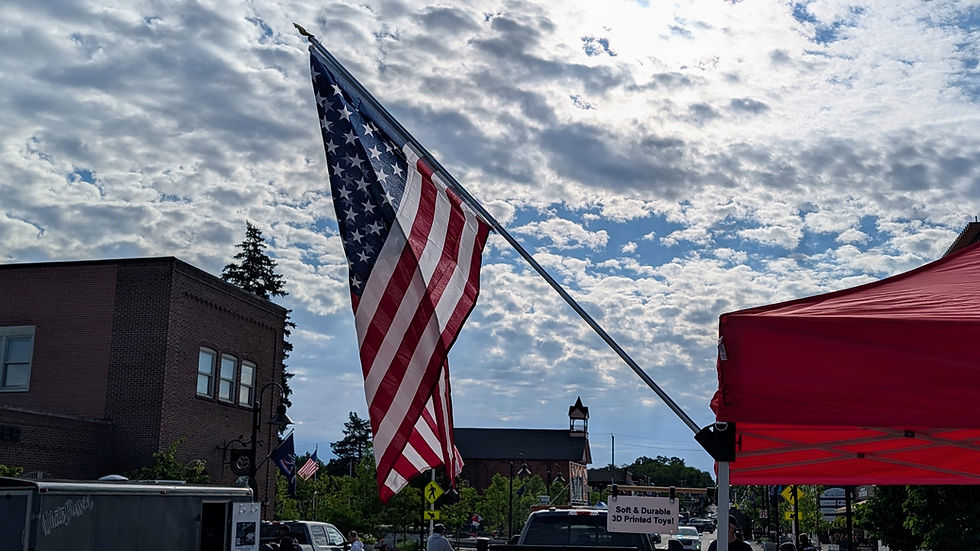American flag displayed from a TentGrip Booth Beacon angled canopy mount at an outdoor event