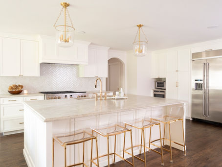 Chef's kitchen featuring quartzite countertops, stainless steel appliances and custom vent hood