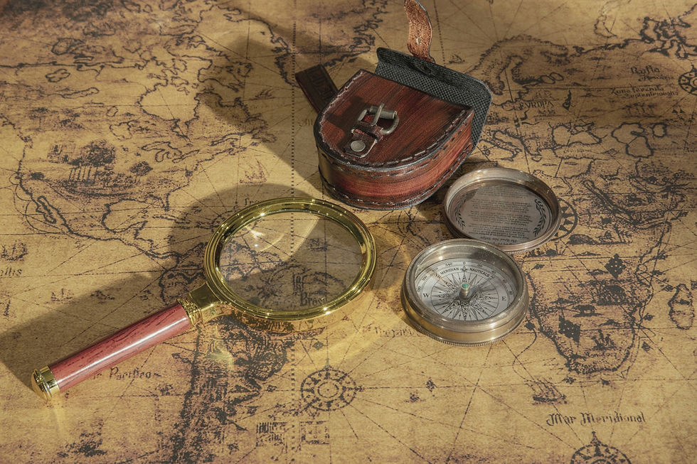 Boussole et loupe posées sur une carte ancienne symbolisant le discernement nécessaire pour décider d'une reconversion professionnelle après un burn-out