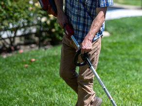 A man weedwacking in his year, a function associated with Residential Landscape Construction in Worcester MA