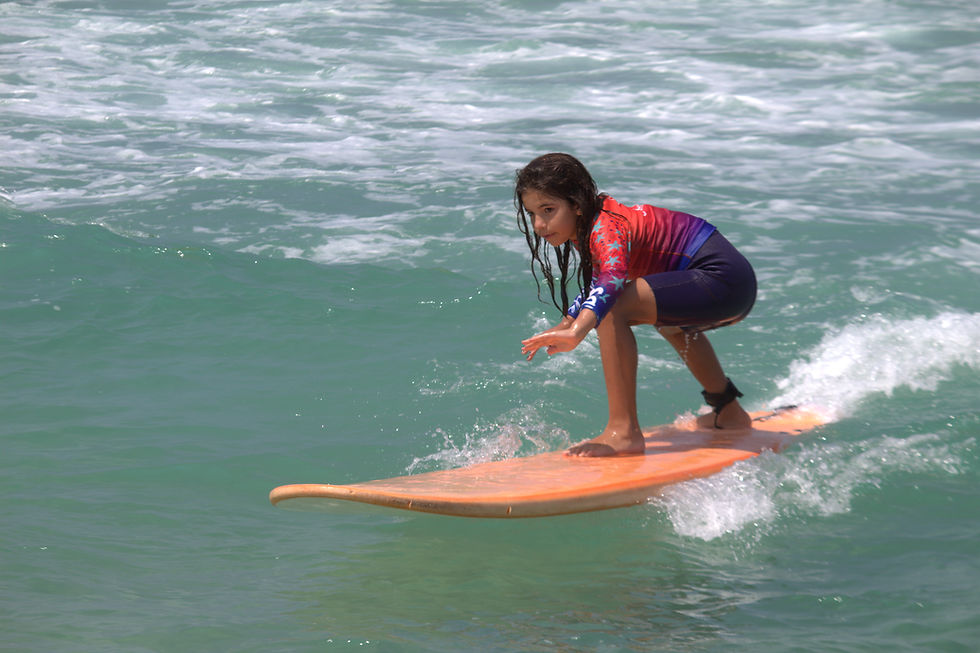 Entre ondas e aprendizados. Crianças em suas primeiras experiências no surf, transformando o mar em sala de aula.
