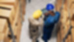 Diverse employees analyzing inventory list on laptop, counting products in boxes on storage room shelves. Two men using device to work on stock logistics, delivery service.