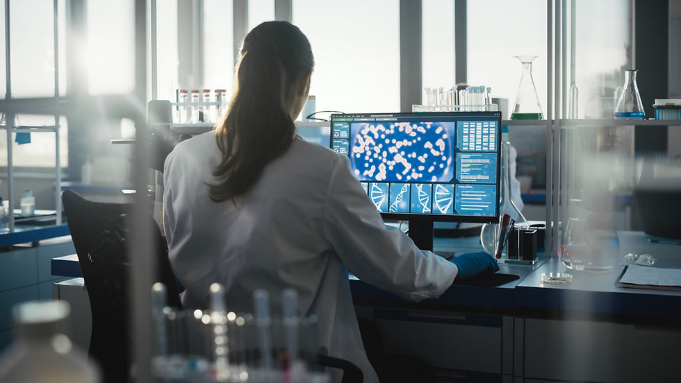 Scientist in a lab coat analyzes DNA sequences on a computer. Lab equipment and test tubes are visible. Bright, focused setting.