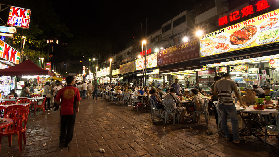 patrons sitting in chairs in Jalan Alor at night