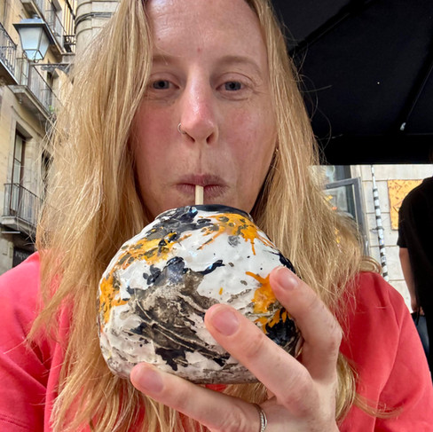 A woman drinking out of a ceramic cup with a straw