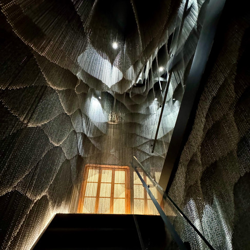 A stairway with metal strands hanging from the ceiling