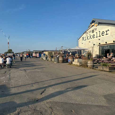A brewery building called Mikkeller with outdoor seating