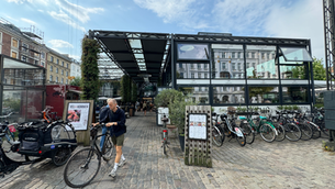 A man with a bike in front of an indoor market building