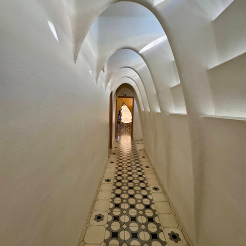 A hallway with white archways and tile floor