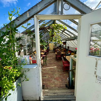 The front door of a cafe with tables inside