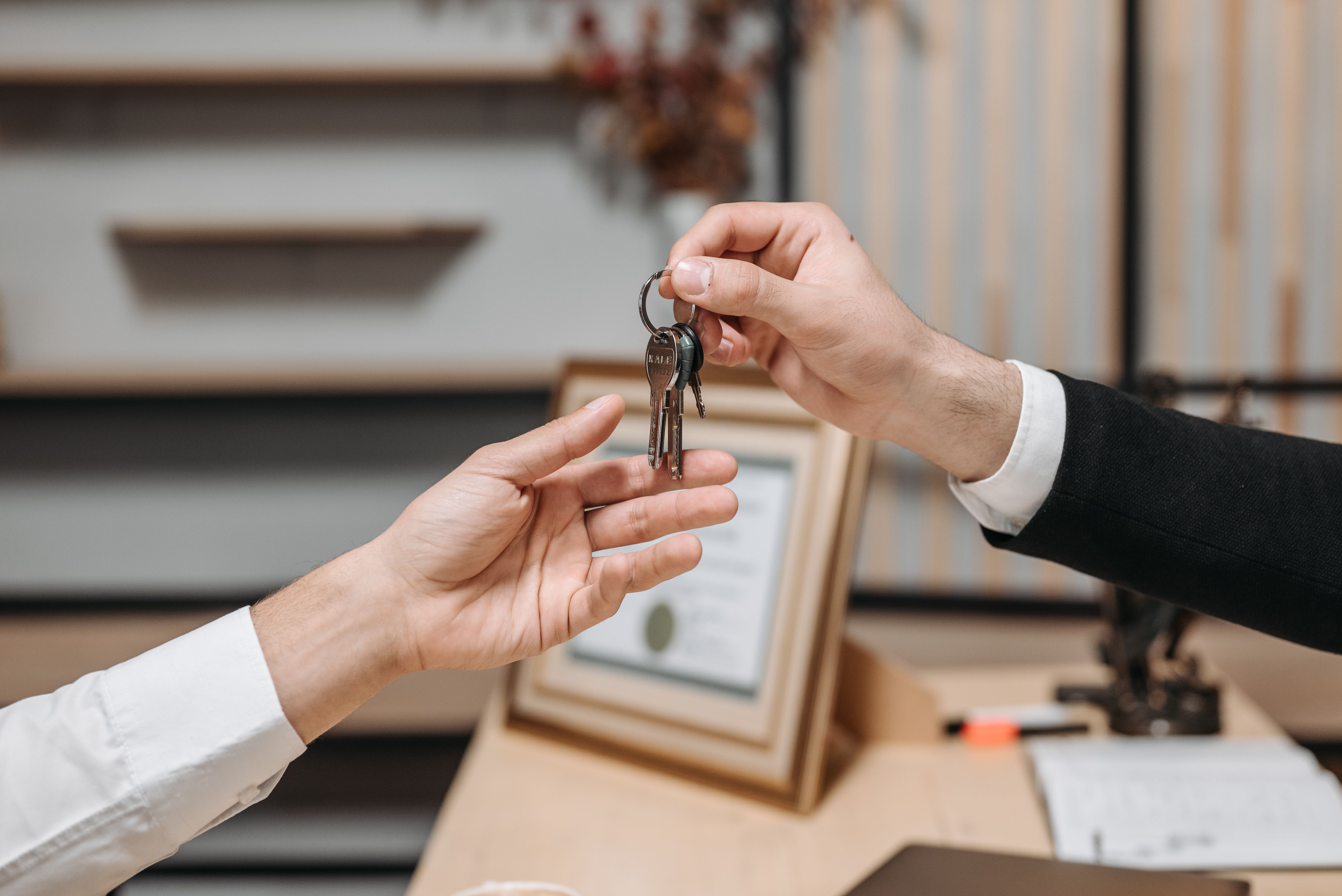 Hands passing a set of house keys